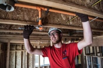 Construction worker inspecting wooden beams inside a building.
